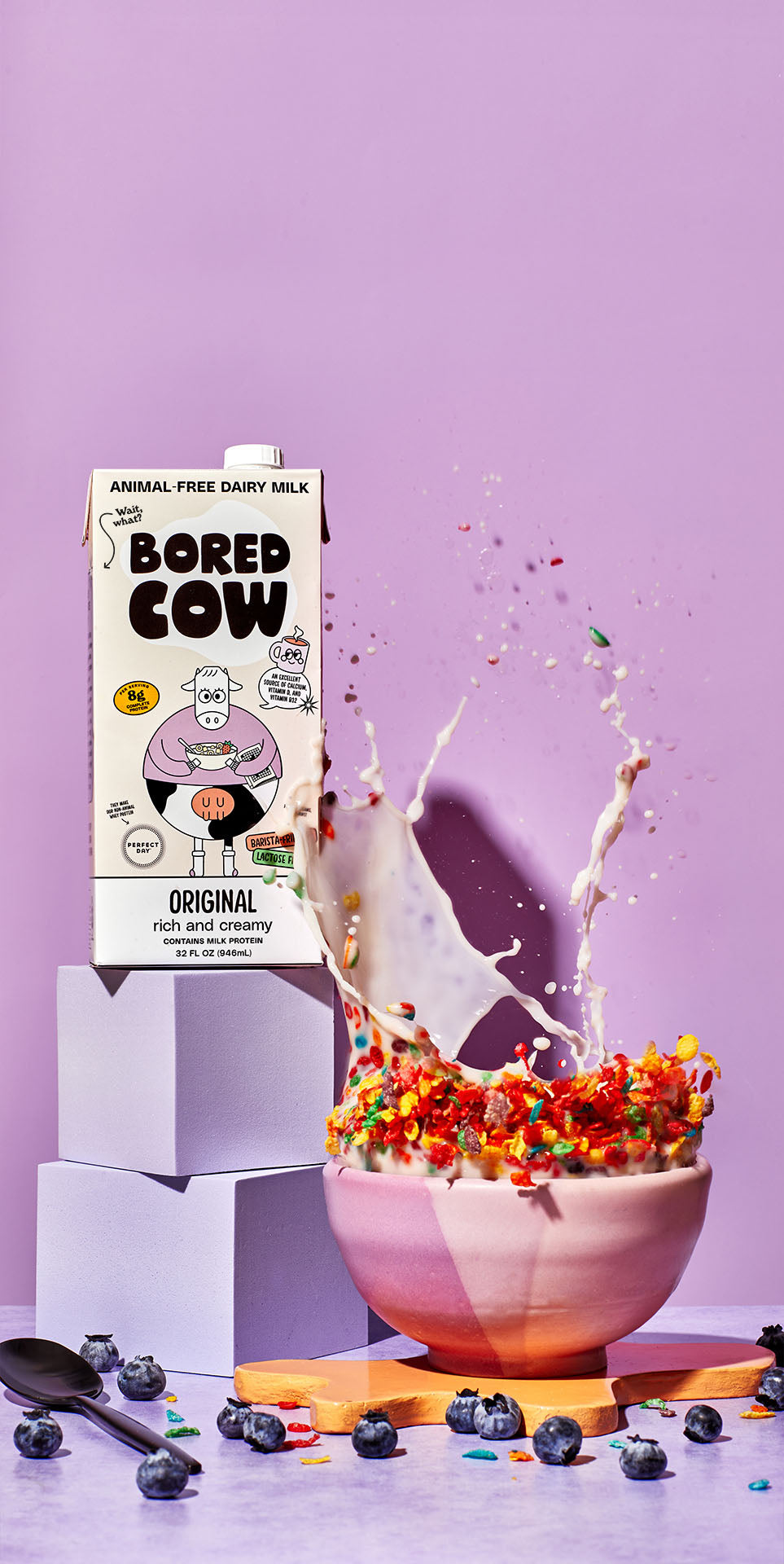 carton of 32 oz Original flavor Bored Cow animal-free dairy milk, to the right is a bowl of cereal with milk splashing out of it